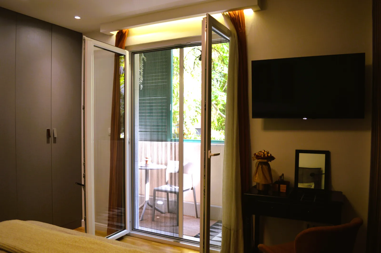 The bedroom with its balcony doors open onto the greenery