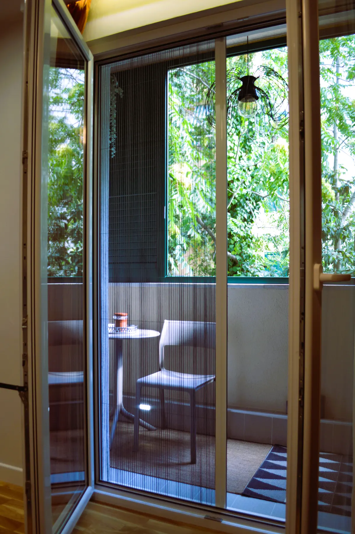 The balcony seen from the bedroom through open doors