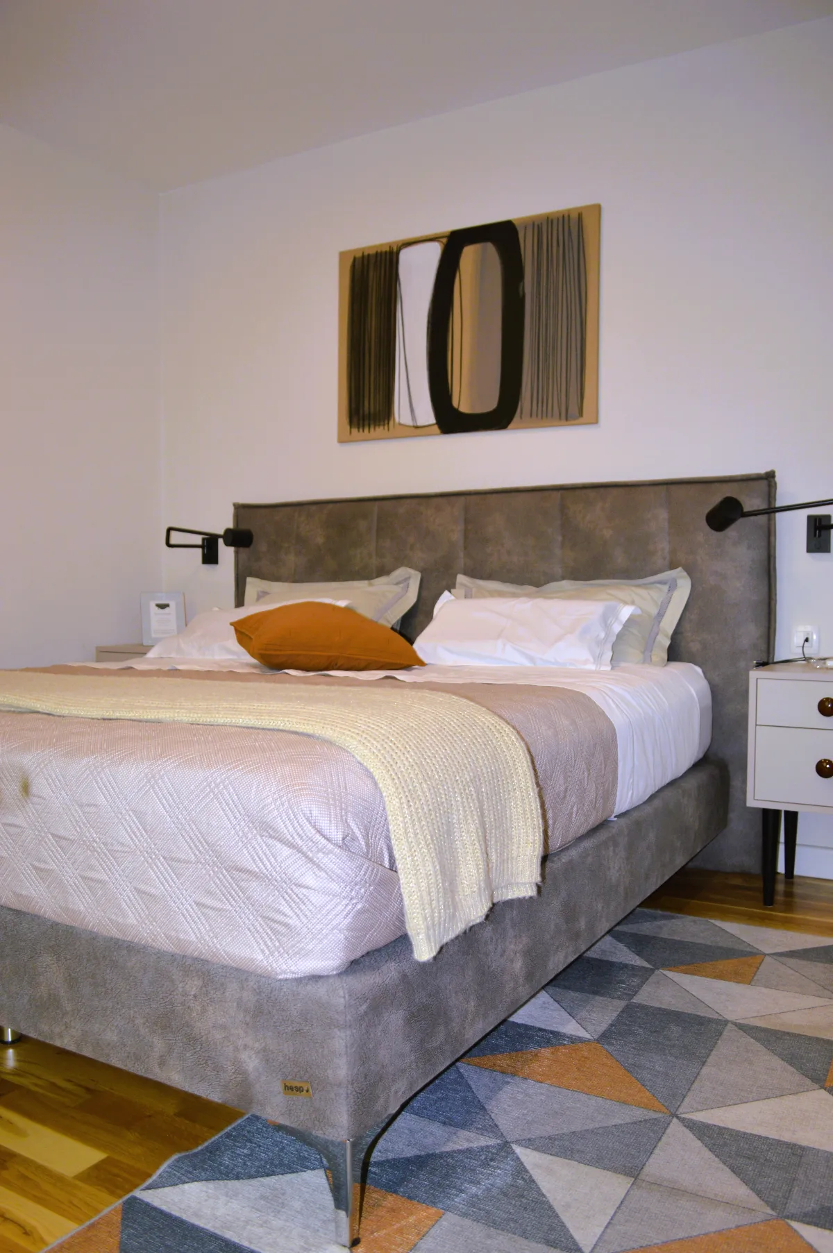 Bedroom with an upholstered bed and folded towels